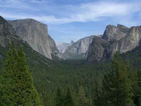 The "tunnel view" of the Yosemite Valley. It is called "tunnel view" since it is right at the mouth of a tunnel that you drive through to enter the valley from the south. From this point you can see El Capitan (the steep bare rock face to the left), Half-Dome (the almost white peak curving up in the background in the middle of the picture) and Bridal Veil Falls (just to the left of the top of the right foreground pine trees - you only see a small vertical white line). The "tunnel view" of the Yosemite Valley. It is called "tunnel view" since it is right at the mouth of a tunnel that you drive through to enter the valley from the south. From this point you can see El Capitan (the steep bare rock face to the left), Half-Dome (the almost white peak curving up in the background in the middle of the picture) and Bridal Veil Falls (just to the left of the top of the right foreground pine trees - you only see a small vertical white line).