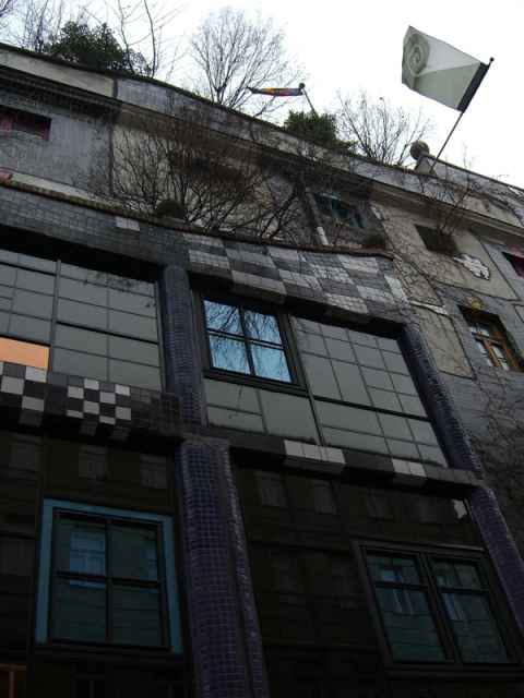 The entrance to the KunstHausWien. On top of the building flies the Koru Flag, an alternative flag for New Zealand designed by Hundertwasser. It includes the spiral, one of Hundertwasser's trademark shapes (if not the trademark shape): The entrance to the KunstHausWien. On top of the building flies the Koru Flag, an alternative flag for New Zealand designed by Hundertwasser. It includes the spiral, one of Hundertwasser's trademark shapes (if not the trademark shape):